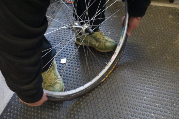 bicycle inner tube Downward pressure with both hands, folding the tyre beading into the rim.