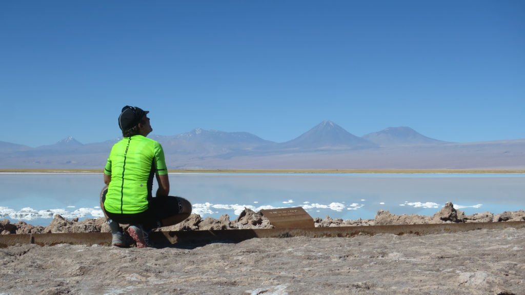 Bike packing in Chile, cycling adventure in Chile, Markus crouches next to a lake