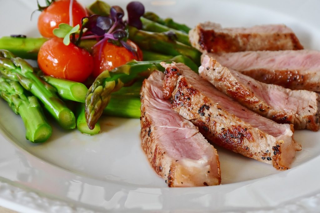 A healthy recovery meal of steak, asparagus and tomato