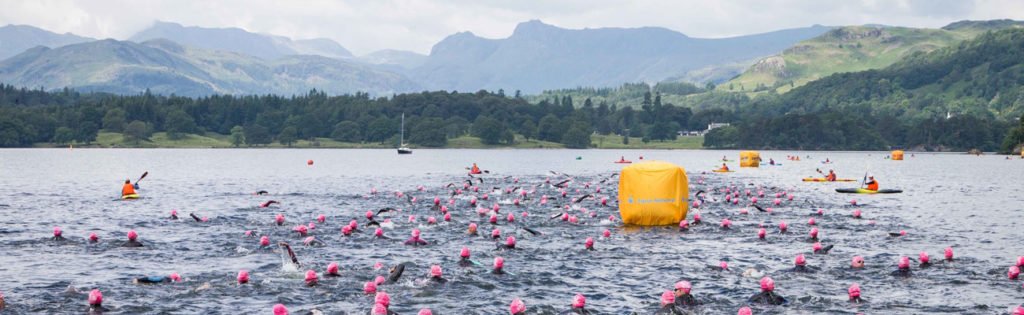 Group of swimmers in pink caps at Loch Lomond,, open water swimming, panoramic shot, day