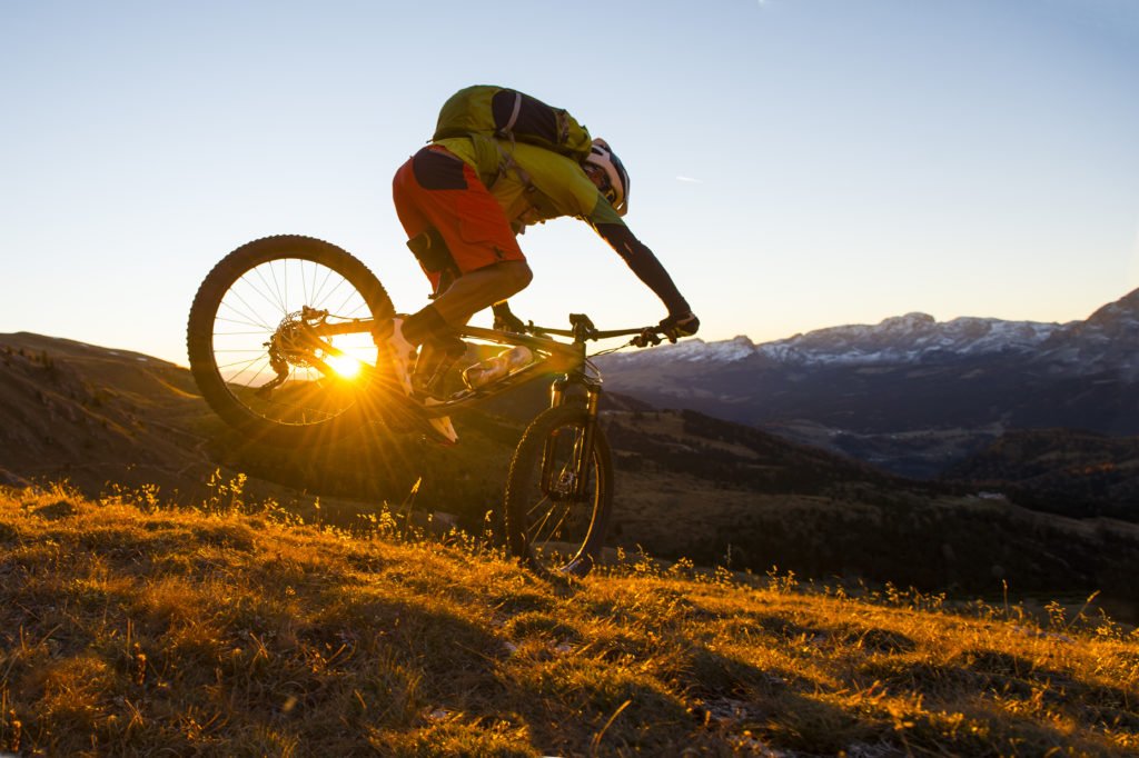 Mountain biker on a mountain, sunny evening, all mountain biking discipline