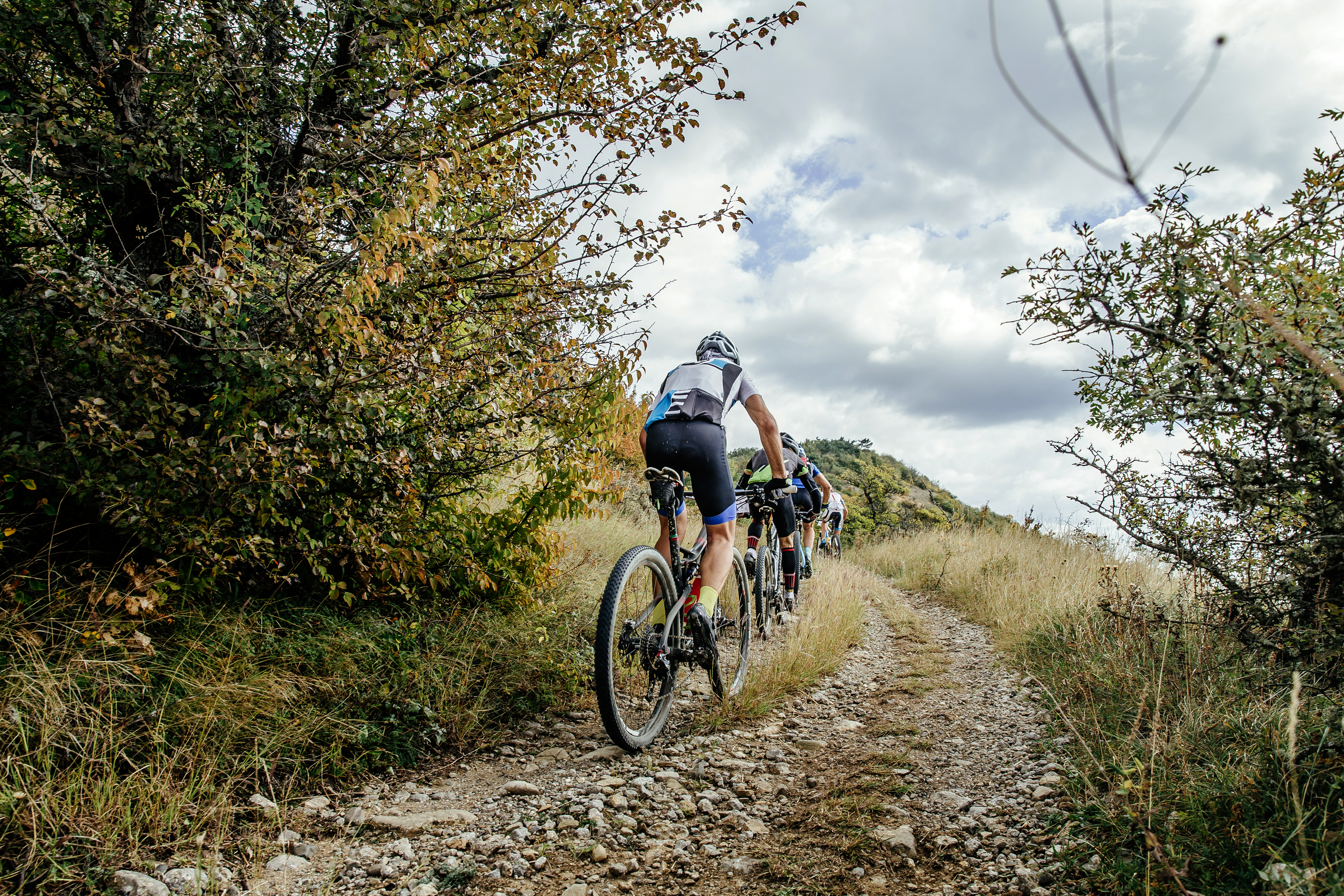 Group of cross country MTB riders, riding up hill, mountain biking discipline