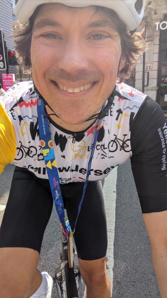 a happy cyclist wearing an event medal after completing a cycle sportive