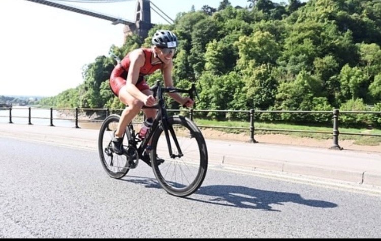 Triathlete riding under the Clifton suspension bridge